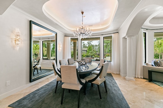 dining area featuring ornamental molding, decorative columns, baseboards, a raised ceiling, and a notable chandelier