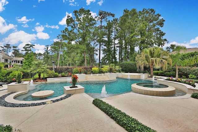 outdoor pool with an in ground hot tub, a patio area, and fence
