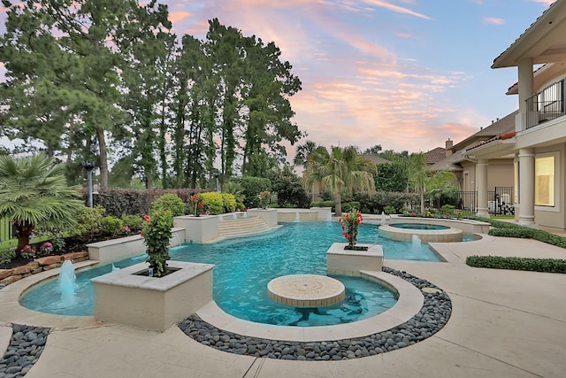 view of pool featuring a pool with connected hot tub and a patio area