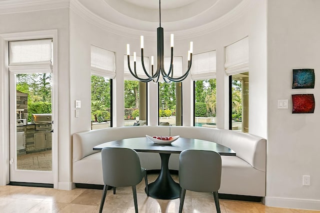 dining room featuring crown molding, baseboards, a wealth of natural light, and a high ceiling
