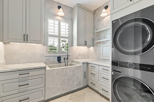laundry room featuring cabinet space and stacked washer / drying machine