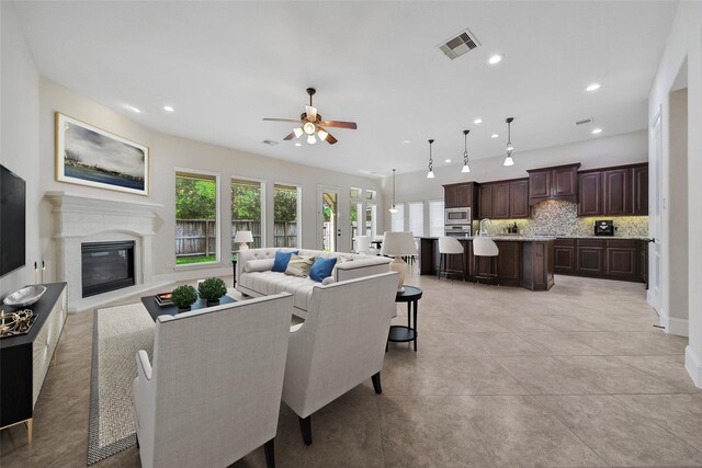 living room featuring ceiling fan, visible vents, a high end fireplace, recessed lighting, and light tile patterned flooring