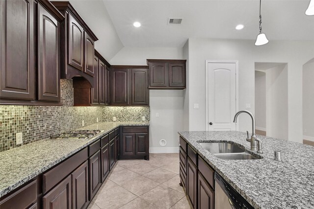 kitchen featuring light stone countertops, appliances with stainless steel finishes, a sink, tasteful backsplash, and visible vents