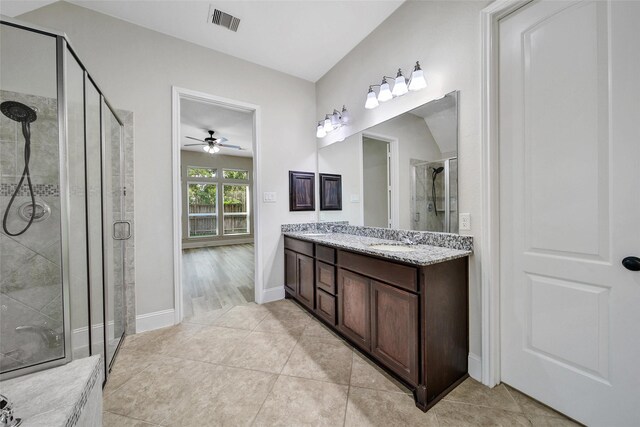 full bath featuring visible vents, a ceiling fan, double vanity, a sink, and a stall shower