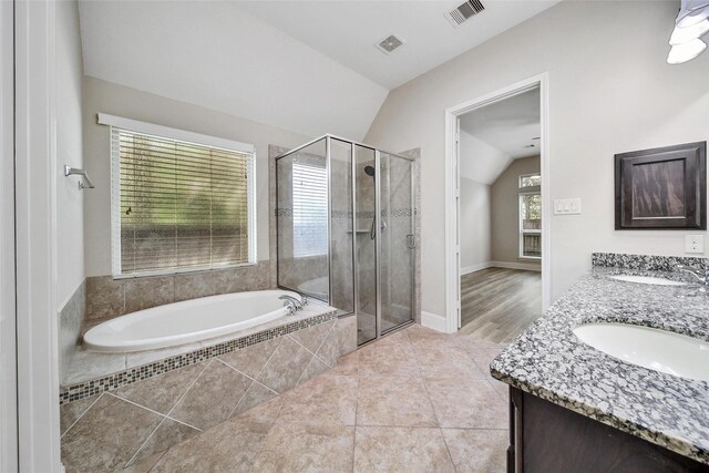 bathroom featuring a bath, visible vents, a shower stall, and lofted ceiling