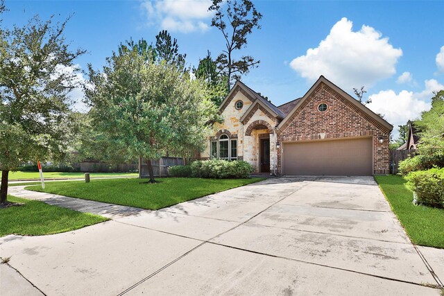 french country style house with a garage, fence, driveway, and a front lawn