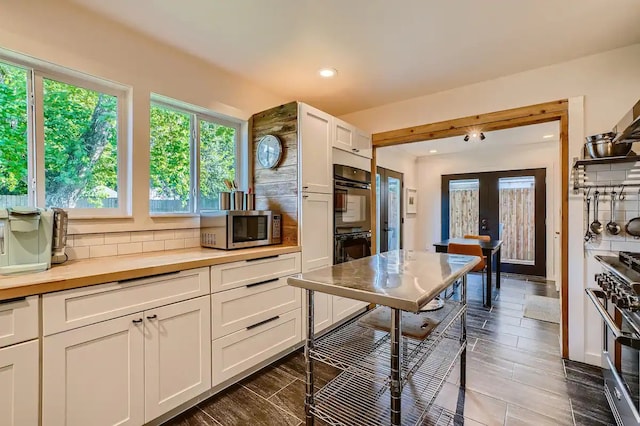 kitchen featuring white cabinets, backsplash, stainless steel appliances, and recessed lighting
