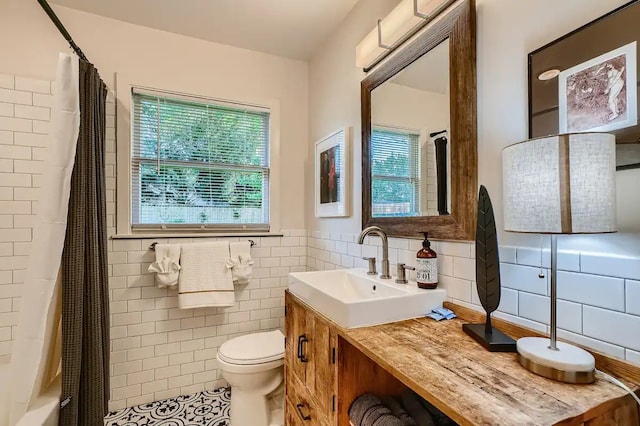 bathroom featuring vanity, curtained shower, toilet, tile walls, and tile patterned floors