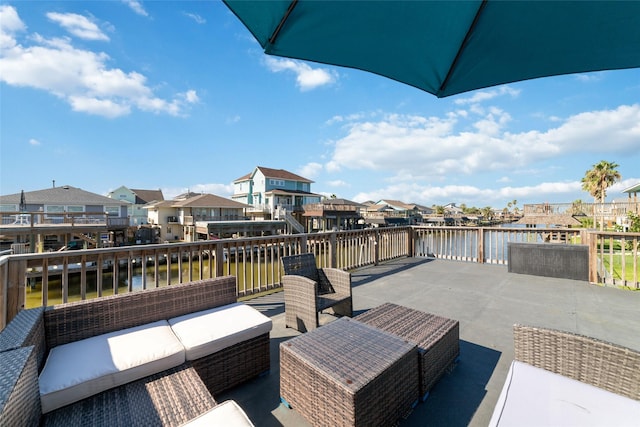 view of patio / terrace with an outdoor living space, a water view, and a residential view