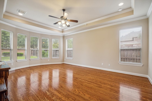 unfurnished room featuring a tray ceiling, visible vents, and a healthy amount of sunlight