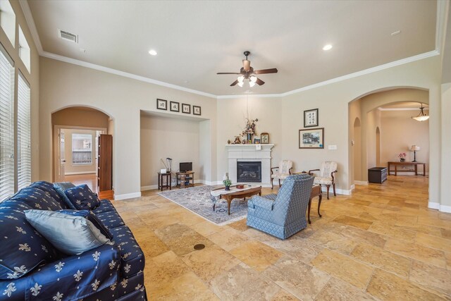 living area featuring visible vents, arched walkways, ceiling fan, and stone tile floors