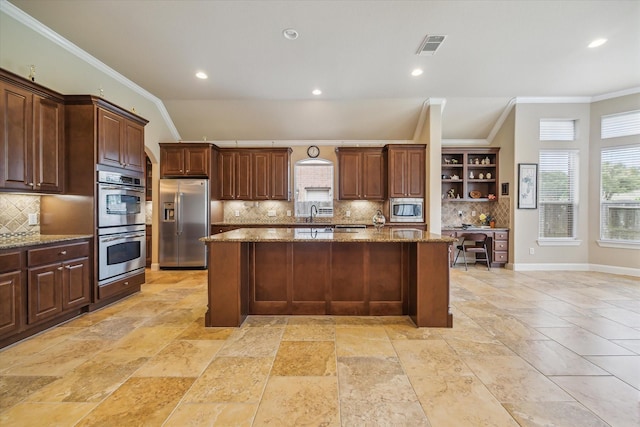 kitchen with ornamental molding, an island with sink, backsplash, and stainless steel appliances