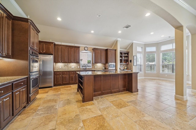 kitchen featuring crown molding, a sink, stainless steel appliances, backsplash, and visible vents