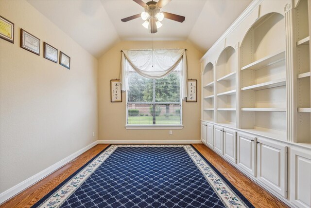 interior space featuring light wood-type flooring, a ceiling fan, baseboards, and lofted ceiling