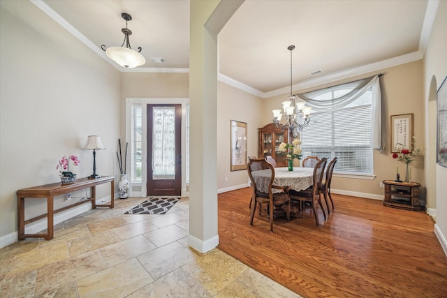 foyer entrance featuring a healthy amount of sunlight, baseboards, ornamental molding, and arched walkways