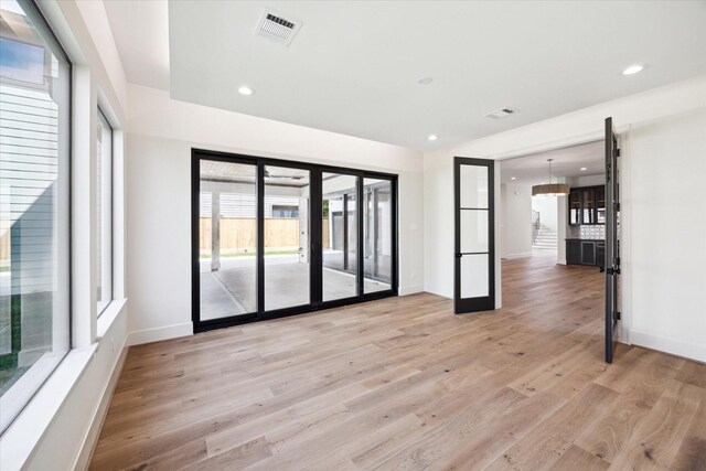 interior space featuring light wood-style floors, baseboards, recessed lighting, and visible vents