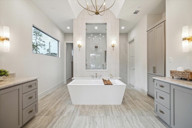 full bath featuring visible vents, a freestanding bath, walk in shower, baseboards, and a chandelier