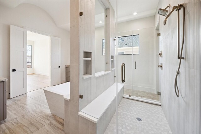 bathroom featuring vanity, a bathtub, and a stall shower