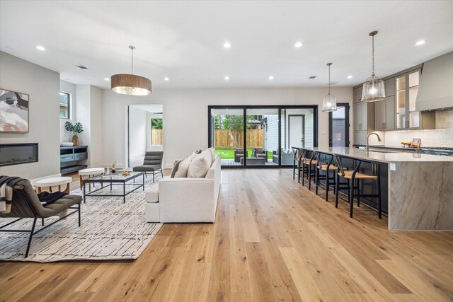 living room featuring light wood-style floors, recessed lighting, and visible vents