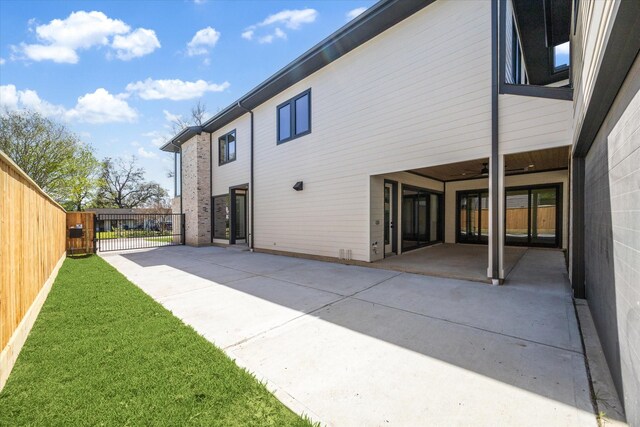 back of house featuring a gate, a patio area, and fence