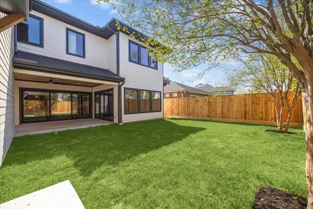 view of yard with a fenced backyard, ceiling fan, and a patio area