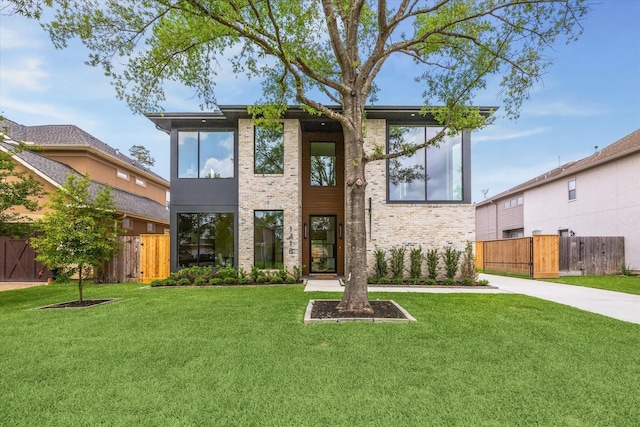 exterior space with a lawn, brick siding, and fence
