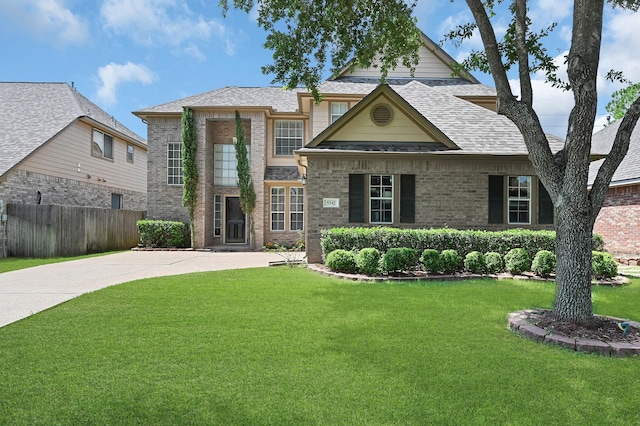 5542 Morgan Park Ln, Sugar Land, TX 77479 - view of front of house featuring fence, a shingled roof, a front lawn, brick siding, and driveway