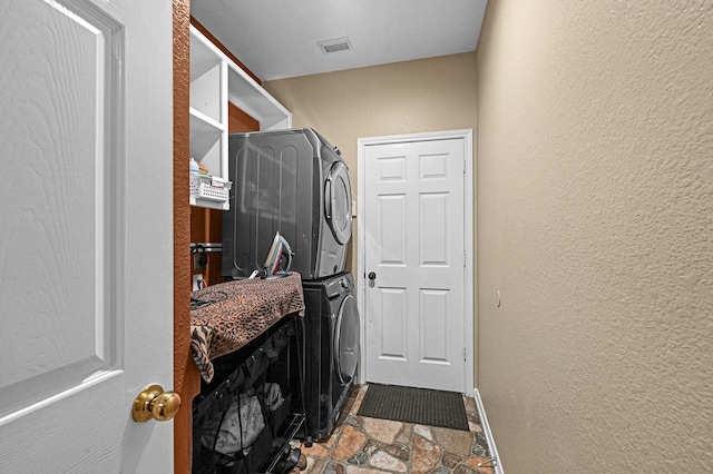 5542 Morgan Park Ln, Sugar Land, TX 77479 - laundry area featuring laundry area, stone tile flooring, a textured wall, visible vents, and stacked washer / dryer