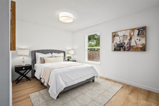 bedroom with baseboards and wood finished floors