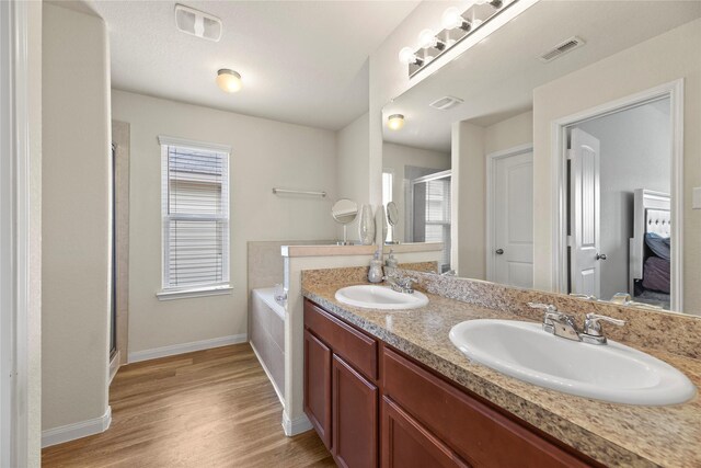 bathroom featuring baseboards, a shower stall, a sink, and wood finished floors
