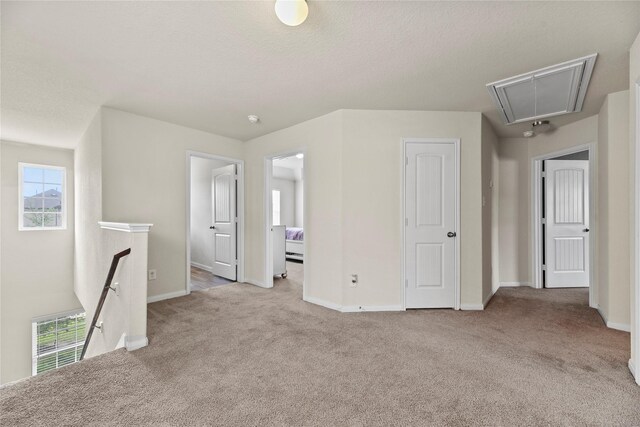 bonus room with carpet floors, baseboards, attic access, and visible vents