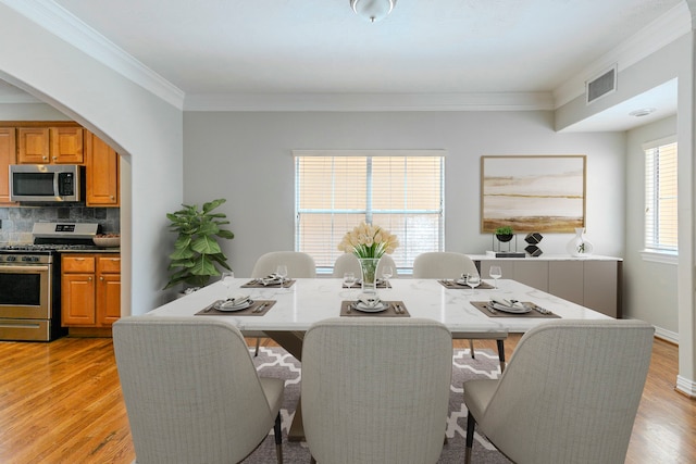 9907 Adeline Ln, Houston, TX 77054 - dining area with crown molding, light wood finished floors, and arched walkways
