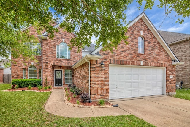 traditional home with a front lawn, brick siding, a shingled roof, an attached garage, and driveway