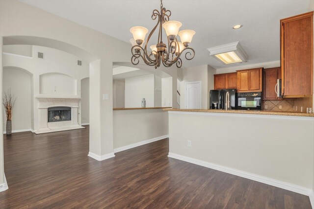 kitchen featuring a chandelier, brown cabinetry, decorative backsplash, dark wood-style floors, and black appliances