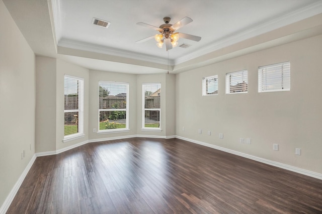 empty room with crown molding, dark wood-style flooring, a ceiling fan, and a raised ceiling