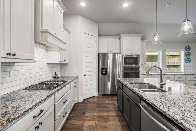 kitchen featuring pendant lighting, recessed lighting, white cabinets, a sink, and stainless steel appliances