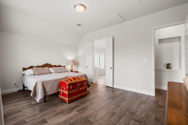 bedroom with baseboards, visible vents, vaulted ceiling, and dark wood-type flooring
