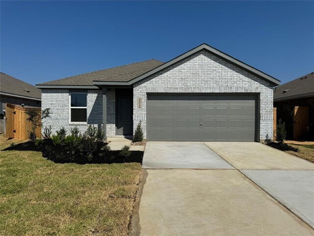 408 Emma St, Angleton, TX 77515 - ranch-style house featuring brick siding, driveway, an attached garage, and a front yard