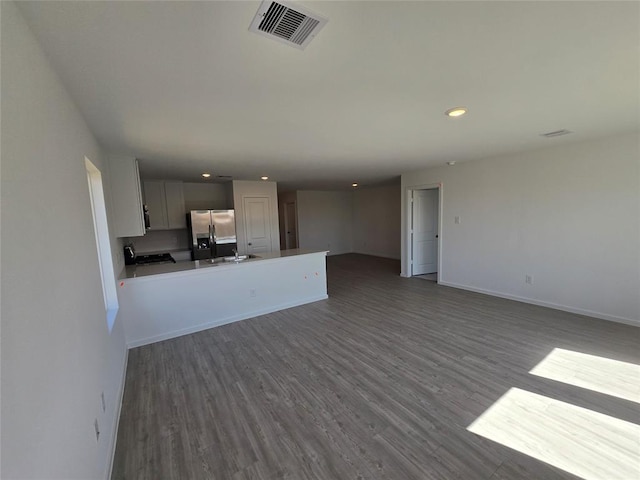 408 Emma St, Angleton, TX 77515 - unfurnished living room with recessed lighting, dark wood-style flooring, baseboards, and a sink