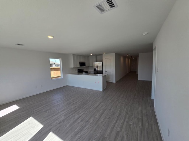 408 Emma St, Angleton, TX 77515 - unfurnished living room featuring dark wood-style flooring, baseboards, and recessed lighting