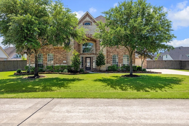 2411 Lakeway Dr, Friendswood, TX 77546 - view of front of house with brick siding, a front lawn, fence, and stone siding
