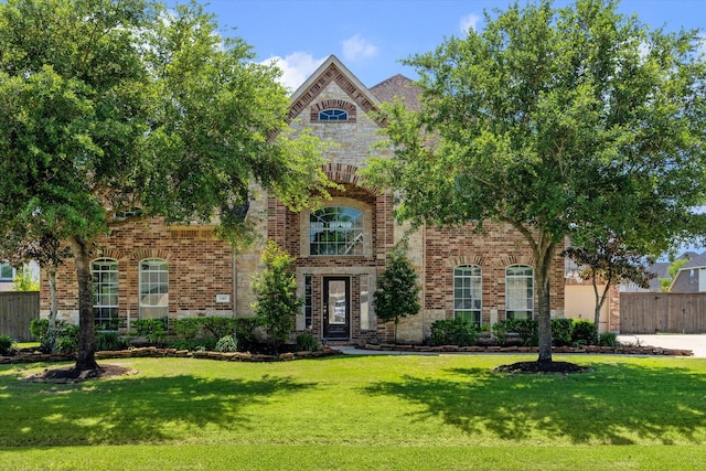 2411 Lakeway Dr, Friendswood, TX 77546 - view of front of house featuring brick siding, fence, and a front yard