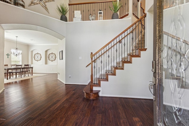 2411 Lakeway Dr, Friendswood, TX 77546 - entrance foyer with crown molding, arched walkways, wood finished floors, a chandelier, and stairs