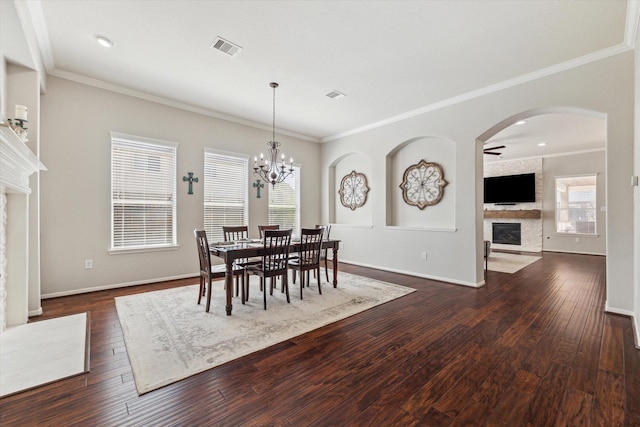 2411 Lakeway Dr, Friendswood, TX 77546 - dining space featuring crown molding, visible vents, dark wood-type flooring, and a fireplace