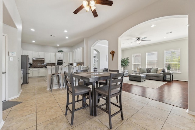 2411 Lakeway Dr, Friendswood, TX 77546 - dining space featuring ceiling fan, visible vents, arched walkways, recessed lighting, and light tile patterned flooring