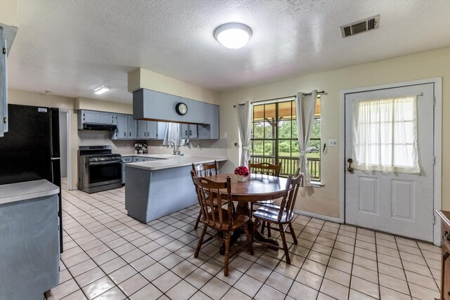 dining space with a textured ceiling, visible vents, plenty of natural light, and light tile patterned floors