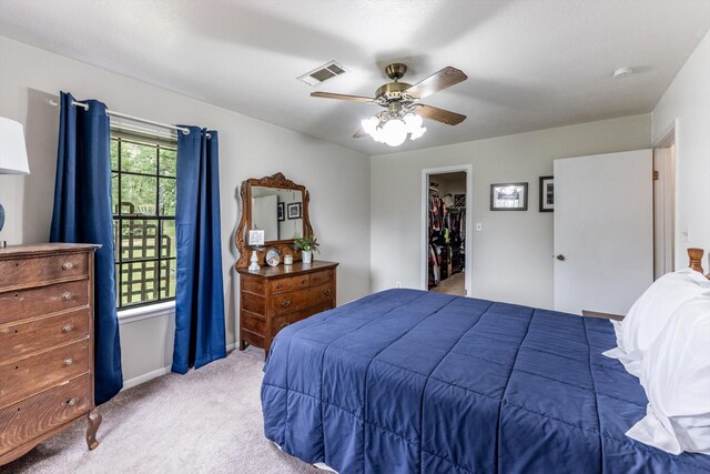 carpeted bedroom featuring ceiling fan, visible vents, baseboards, a closet, and a spacious closet