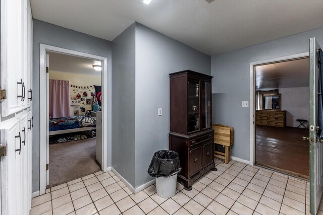hall with baseboards and light tile patterned flooring