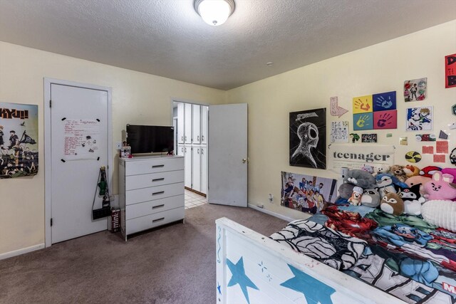 bedroom with baseboards, carpet flooring, and a textured ceiling