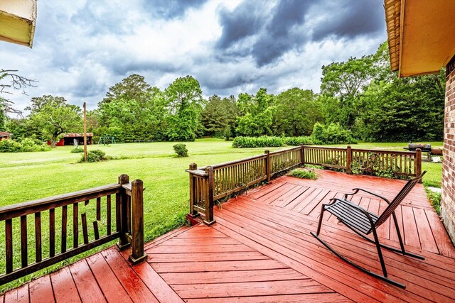wooden deck featuring a lawn